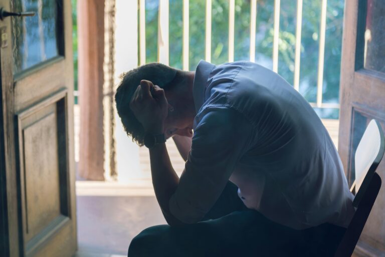 Personne assise, tête entre les mains, illustrant une fatigue émotionnelle et un épuisement face à certaines situations